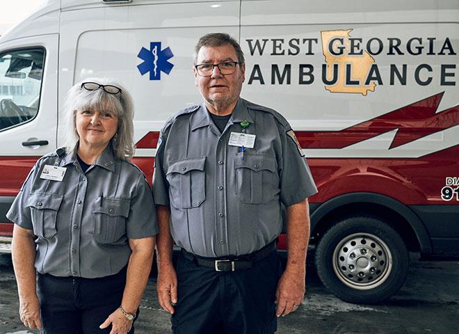 2 EMTs standing in front of their West Georgia Ambulance Truck.