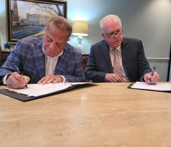 Steve Adams and Loy Howard signing papers